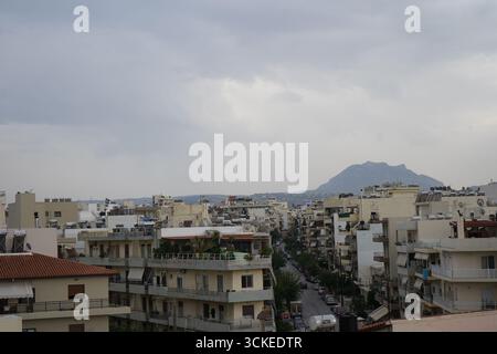 Una vista elevata del fitto paesaggio urbano di Heraklion con una montagna in un giorno coperto, che offre uno sguardo sulla vita della città dell'isola. Foto Stock
