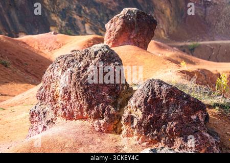 Formazione rocciosa di bauxite erosa con colori arancio brillanti in una miniera di bauxite abbandonata Foto Stock