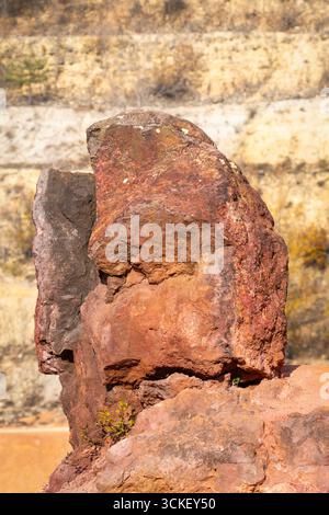 Formazione rocciosa di bauxite erosa con colori arancio brillanti in una miniera di bauxite abbandonata Foto Stock