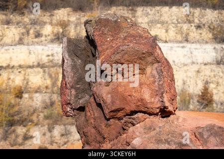 Formazione rocciosa di bauxite erosa con colori arancio brillanti in una miniera di bauxite abbandonata Foto Stock