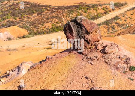 Formazione rocciosa di bauxite erosa con colori arancio brillanti in una miniera di bauxite abbandonata Foto Stock