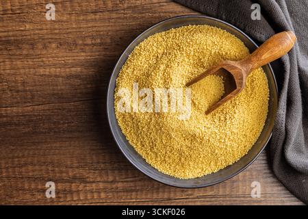 Couscous crudo in una ciotola su un tavolo di legno. Vista dall'alto. Foto Stock