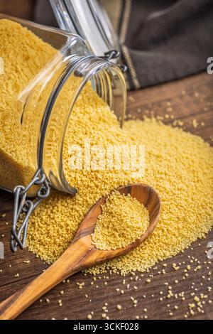Couscous crudo su un tavolo di legno. Foto Stock