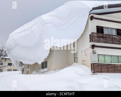 Un'enorme quantità di neve si è accumulata sul tetto di un hotel dopo una forte nevicata in Giappone. Foto Stock