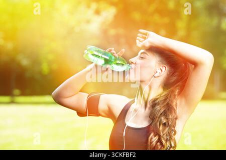 giovane donna sportiva che beve da una bottiglia d'acqua Foto Stock