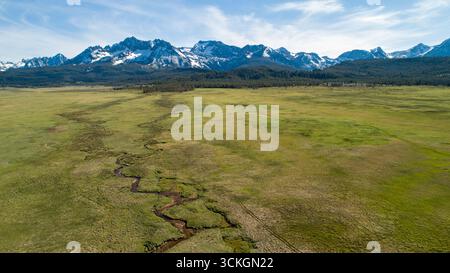 Un grande campo aperto con un fiume che lo attraversa Foto Stock