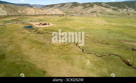 Un grande campo aperto con un fiume che lo attraversa Foto Stock