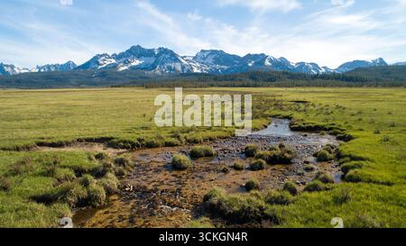 Un campo ampio e aperto con un flusso che lo attraversa Foto Stock