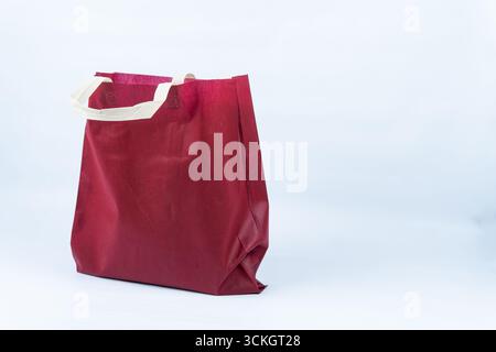 Borsa per la spesa in tessuto riutilizzabile rossa con manici beige isolata su sfondo bianco. Perfetto per lo stile di vita ecologico, lo shopping sostenibile e il design retail. Foto Stock