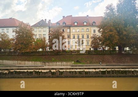Slovenia, Lubiana - 23 settembre 2022: Una splendida scena autunnale sulle rive del fiume con edifici storici tra lo splendore delle creature naturali Foto Stock