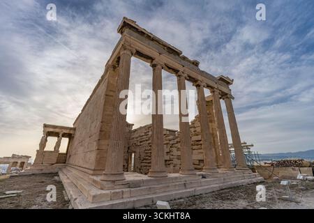 Vista obliqua del tempio dell'Eretteo sull'Acropoli di Atene, in Grecia, che mostra le colonne ioniche del tempio in primo piano con il portico cariatide Foto Stock