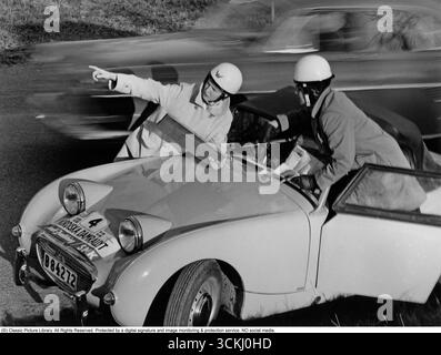 Austin-Healey Sprite MK1 Frogeye: Icona del Rally Spirit degli anni '1960. In questa vibrante immagine del 1960 del Nordic Women's Rally, due partecipanti femminili si trovano accanto alla Austin-Healey Sprite MK1 "Frogeye", un'auto sportiva britannica compatta celebrata per i suoi fari sgargianti e simili a rane e per il rivoluzionario design monoscocca. Lanciata nel 1958 da Donald Healey Motor Company sotto la guida di BMC, la Sprite offriva un divertimento accessibile con un motore da 948 cc serie A da 43 cv, trazione posteriore e un telaio leggero da 1.500 lb, ideale per una guida vivace e per gli sport motoristici. Il suo significato risiede nella democratizzazione dello sport CA Foto Stock