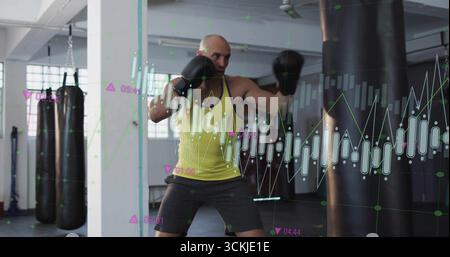Pugni uomo con la parte superiore gialla e guanti che danno pugno in palestra, con sacco pesante e sovrapposizioni di carte Foto Stock