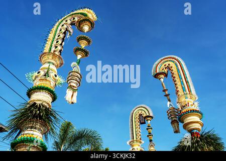 Penjor balinese contro il cielo blu a Desa Munggu Bali Indonesia Foto Stock