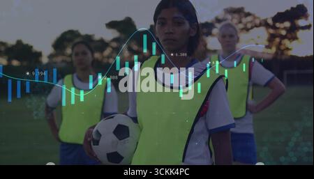 Giocatore di calcio con palla bianca e nera sul campo di erba al crepuscolo, con bavaglino giallo neon Foto Stock
