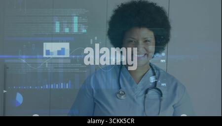 Infermiere sorridente che visualizza grafici e grafici medici digitali con stetoscopio e badge ID in clinica Foto Stock