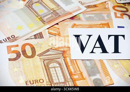 IVA testo con le banconote in euro come sfondo. Foto Stock
