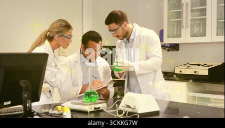 Soluzioni di misurazione e registrazione dei dati al banco di laboratorio, chimici in camici da laboratorio e occhiali di protezione con matracci Foto Stock