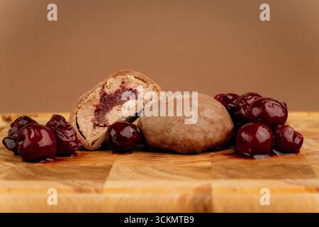 Dessert al mochi di ciliegia al cioccolato con succose ciliegie intere su tavola di legno, shot studio Foto Stock