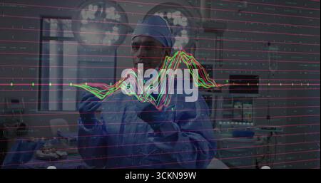 Chirurgo in posizione eretta che indossa il cappuccio blu scrub sotto le luci chirurgiche in sala operatoria, sovrapposizione delle forme d'onda Foto Stock