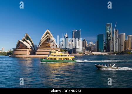 Splendida vista panoramica della Sydney Opera House con le barche nel porto contro l'iconico skyline della città sotto un cielo azzurro, catturando un'essenza Foto Stock