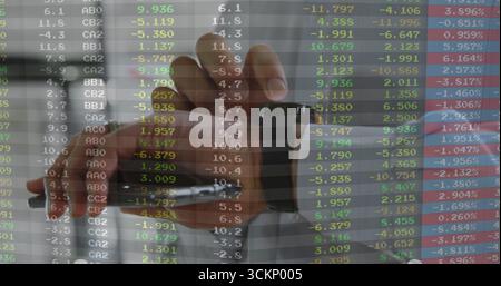 Timbratura della data in gomma con la mano destra sulla scrivania dell'ufficio, che mostra la sovrapposizione dei dati delle scorte Foto Stock