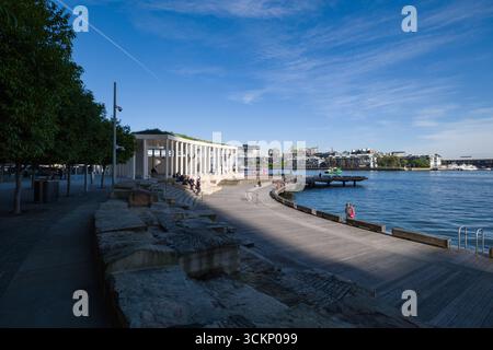 La passeggiata panoramica sul lungomare presenta una moderna struttura architettonica, circondata da elementi naturali e da un vivace skyline cittadino. I visitatori apprezzano la S. Foto Stock