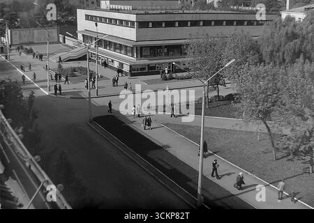 Vista panoramica del grande magazzino Yubileyniy (Jubilee) a Sloviansk, 1976. L'edificio, in stile modernista sovietico e situato in Piazza della Rivoluzione d'ottobre (ora Piazza Soborna), è mostrato come un centro del commercio urbano e della vita sociale. Gli scatti riflettono la vita quotidiana e l'architettura dell'era della stagnazione, simboleggiando la vita pacifica e ben tenuta a Donbas, dove il negozio centrale era un punto di attrazione per migliaia di cittadini Foto Stock