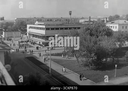 Vista panoramica del grande magazzino Yubileyniy (Jubilee) a Sloviansk, 1976. L'edificio, in stile modernista sovietico e situato in Piazza della Rivoluzione d'ottobre (ora Piazza Soborna), è mostrato come un centro del commercio urbano e della vita sociale. Gli scatti riflettono la vita quotidiana e l'architettura dell'era della stagnazione, simboleggiando la vita pacifica e ben tenuta a Donbas, dove il negozio centrale era un punto di attrazione per migliaia di cittadini Foto Stock