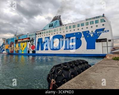 Genova, Italia - 13 settembre 2025: Il traghetto Moby Wonder è ormeggiato nel porto di Genova. La nave passeggeri e RoRo della compagnia di navigazione Moby si distingue per i suoi colorati dipinti a fumetti e collega le città portuali italiane nel Mediterraneo *** Die Autofähre Moby Wonder liegt im Hafen von Genua. DAS Passagier- und RoRo-Schiff der Reederei Moby fällt durch bunte Cartoon-Bemalungen auf und verbindet italienische Hafenstädte im Mittelmeer Foto Stock