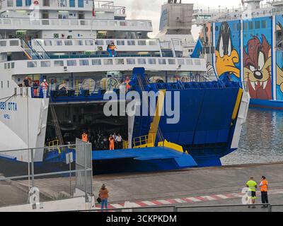 Genova, Italia - 13 settembre 2025: Il traghetto Moby Otta ormeggia nel porto di Genova. I lavoratori portuali e i passeggeri si preparano allo sbarco mentre i veicoli vengono trasportati attraverso il ponte RoRo della compagnia di navigazione Moby *** Die Autofähre Moby Otta legt im Hafen von Genua An. Hafenarbeiter und Passagiere bereiten die Ausschiffung vor, während Fahrzeuge über das RoRo-Deck der Reederei Moby transportiert werden Foto Stock