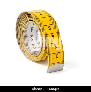 Primo piano del nastro di misurazione giallo arricciato, ideale per progetti di misurazione, personalizzazione o fai da te Foto Stock