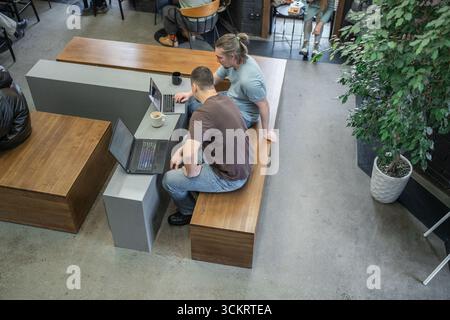 Il team di progetto aziendale lavora insieme nella sala riunioni dell'ufficio. Programmatori che lavorano nell'ufficio di una società di sviluppo software. Codifica Foto Stock
