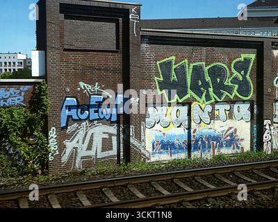 Germania - Graffiti su un muro di confine lungo la ferrovia ferroviaria Foto Stock
