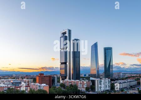 Paesaggio urbano del quartiere finanziario di Madrid al crepuscolo, con moderni grattacieli illuminati contro il cielo serale che svanisce. Quest'area a nord della t Foto Stock