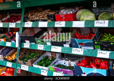 Una vivace esposizione all'esterno di un negozio di alimentari con una varietà di frutta e verdura fresca, tra cui peperoni e cavoli, a Bishops Stortford, Regno Unito. Foto Stock