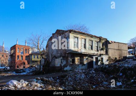 Edifici residenziali storici abbandonati e rovine urbane con mucchi di spazzatura domestica in primo piano, contrasto di architettura abbandonata e Foto Stock