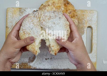 Le mani di una donna stanno tenendo una fetta di torta di mele su un tagliere. Foto Stock