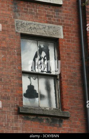 Dublino, Irlanda - 12 settembre 2025 - il riflesso scuro di un'iconica illuminazione stradale ornata di Dublino, appare come un dipinto sui vetri delle finestre di un edificio laterale Liffey nel centro di Dublino Foto Stock