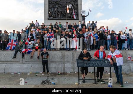 Londra, Regno Unito. 13 settembre 2025. I manifestanti salgono sul plinto di Trafalgar Square durante la manifestazione “Unite the Kingdom” guidata da Tommy Robinson. La marcia, promossa come difesa della libertà di parola e dell'opposizione all'immigrazione. Crediti: Andrea Domeniconi/Alamy Live News Foto Stock
