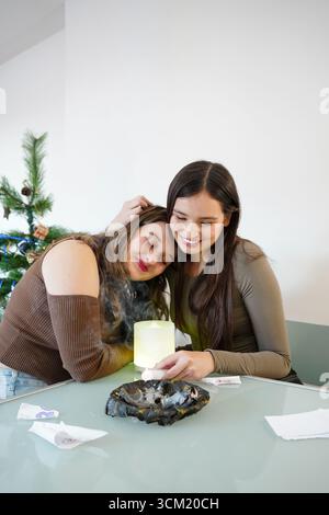Un paio di donne che si godono il rituale di Capodanno insieme Foto Stock