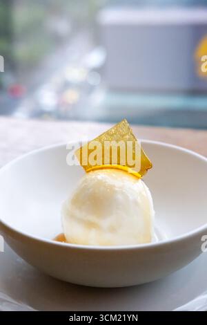 Gelato al miele con condimento, servito in una ciotola bianca Foto Stock