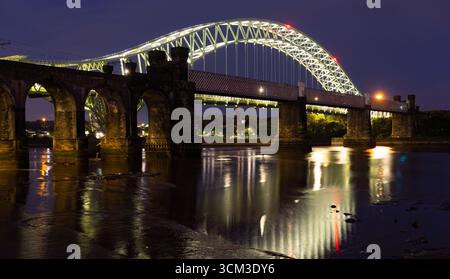 Il Silver Jubilee Bridge, visto dal lato Widnes del fiume Mersey nella zona di Widnes sulla sponda occidentale. Immagine scattata nell'agosto 2025. Foto Stock