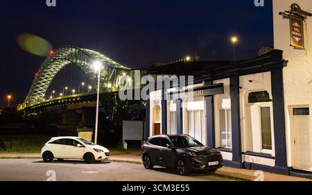 Il Mersey Pub, con il Silver Jubilee Bridge adiacente a Widnes lungo la sponda occidentale del fiume Mersey. Immagine scattata nell'agosto 2025. Foto Stock