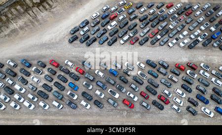 Vista aerea di numerose auto parcheggiate in fila su un terreno di ghiaia. Le auto sono di vari colori e modelli presso il cantiere Copart di York, Regno Unito. Foto Stock