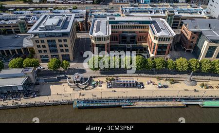 Vista aerea di un paesaggio urbano moderno con un fiume, edifici, una passeggiata sul lungomare e alberi a Newcastle upon Tyne, Regno Unito. Foto Stock