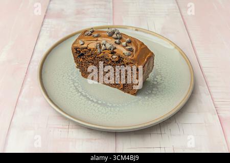 Deliziosa torta in spugna al cioccolato fondente con un morbido centro di fusione, ricoperta di ganache cremose e decorata con lamponi freschi Foto Stock