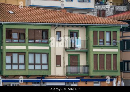 Architettura basca tradizionale con facciate verdi e tende in legno marrone nel nord della Spagna. Case a schiera colorate, tipici edifici Euskadi Foto Stock