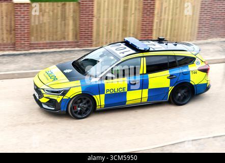 Una moderna pattuglia della polizia britannica della northumbria che guida su una strada, mostrando una livrea a scacchi blu e gialla distinta dal Regno Unito Foto Stock