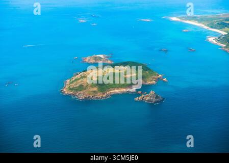 Veduta aerea di Jethou (con due isolotti, Crevichon a nord e Fauconniere a sud), piccola isola, affittata privatamente dalla Corona, appena fuori Foto Stock